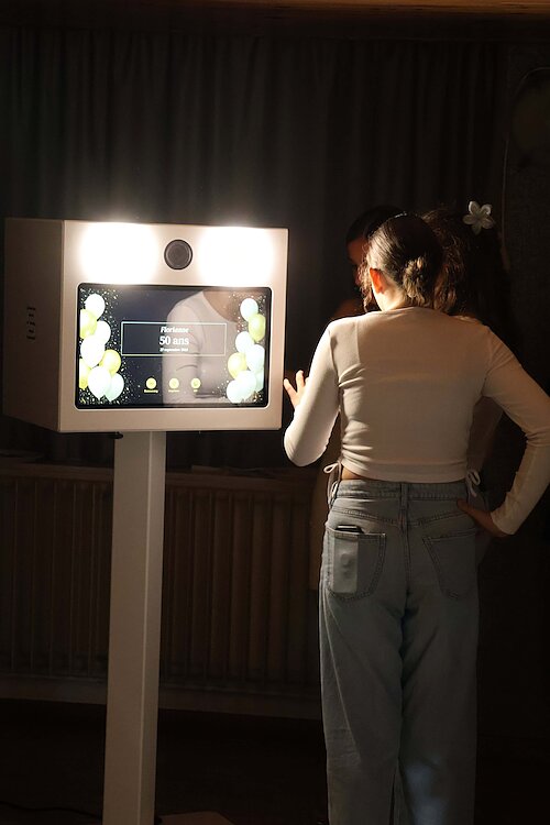 Deux proches posent devant la borne photo FunkyPix installée dans la salle des Merisiers à Villevaudé
