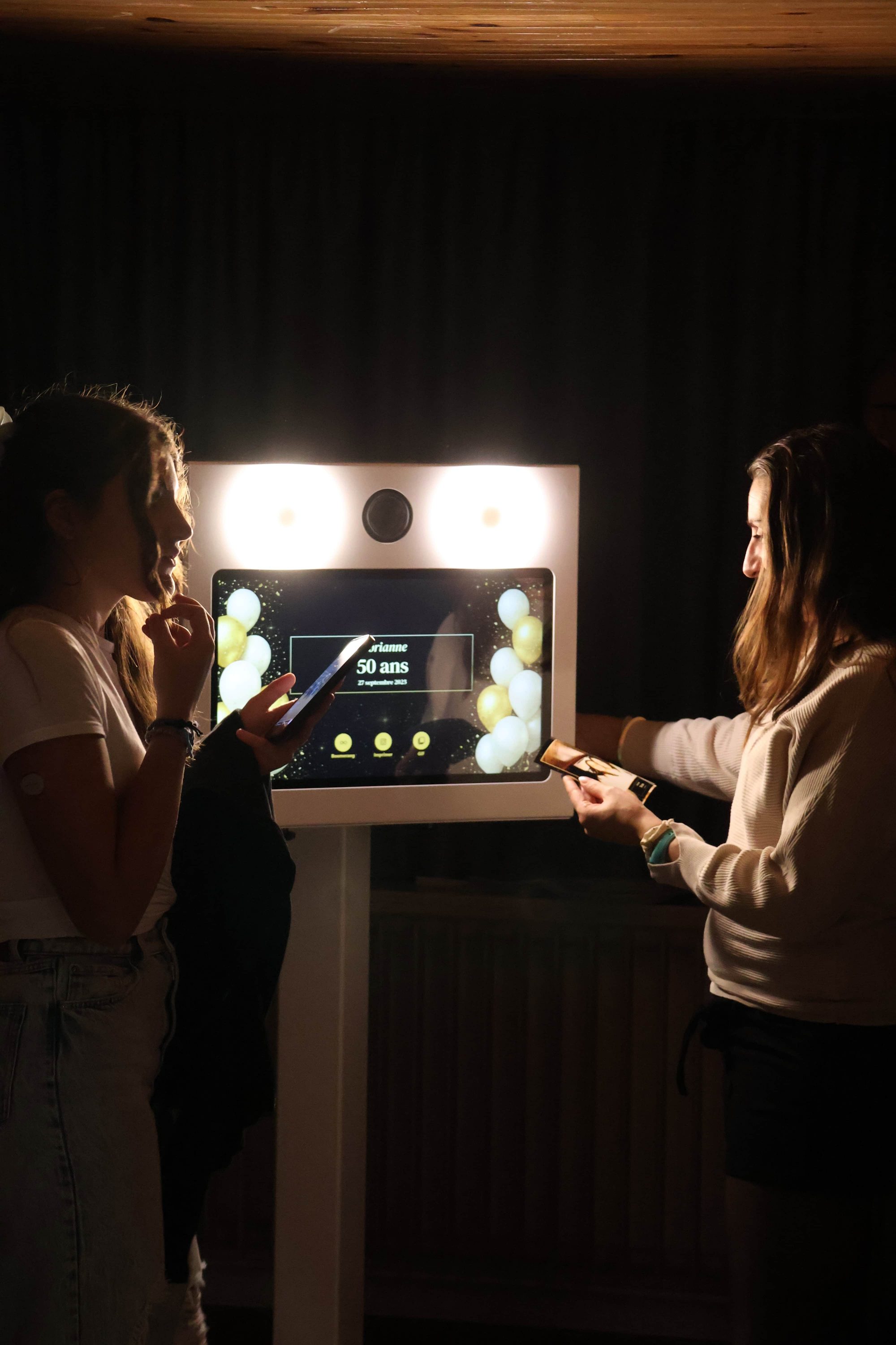 Adolescentes devant la borne photo partageant leurs photos sur les réseaux