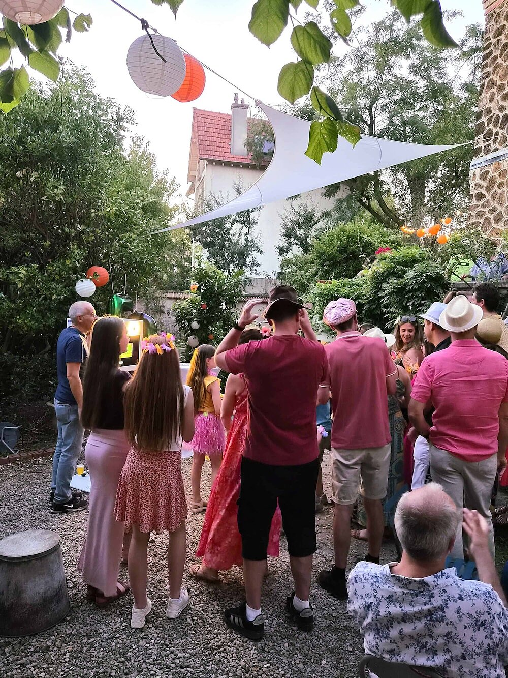 Famille et amis réunis autour du photobooth pendant la soirée d’anniversaire d’Anne