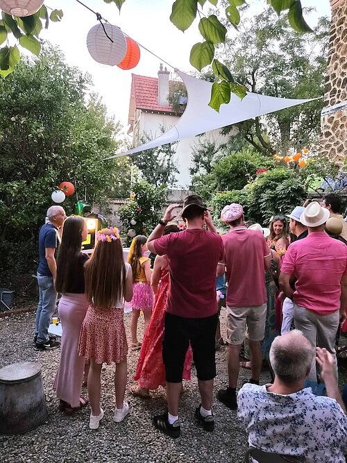 Famille et amis réunis autour du photobooth pendant la soirée d’anniversaire d’Anne