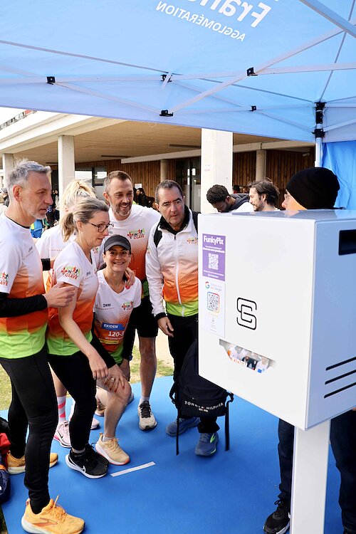 Équipe de coureurs posant devant une borne photo lors de l’Ekiden de Roissy-en-France