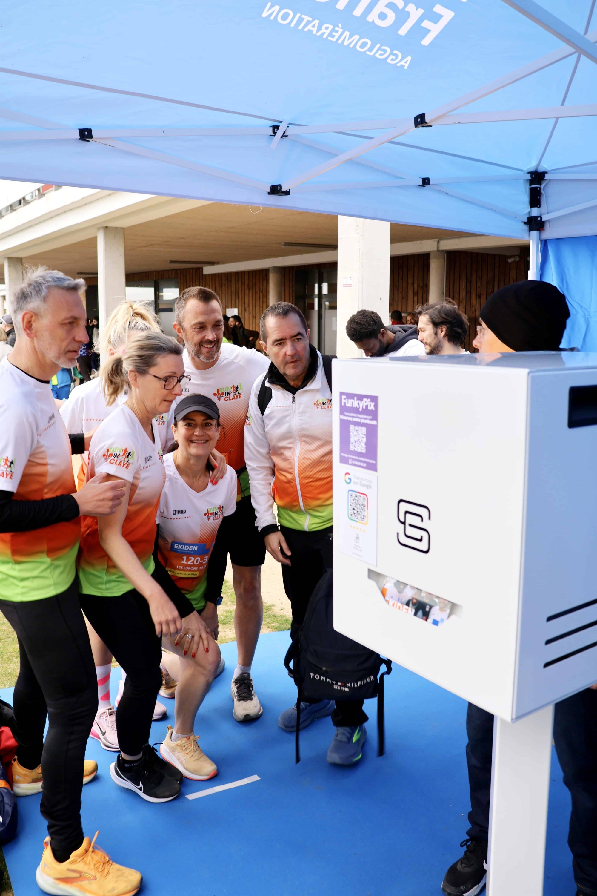 Équipe de coureurs posant devant une borne photo lors de l’Ekiden de Roissy-en-France