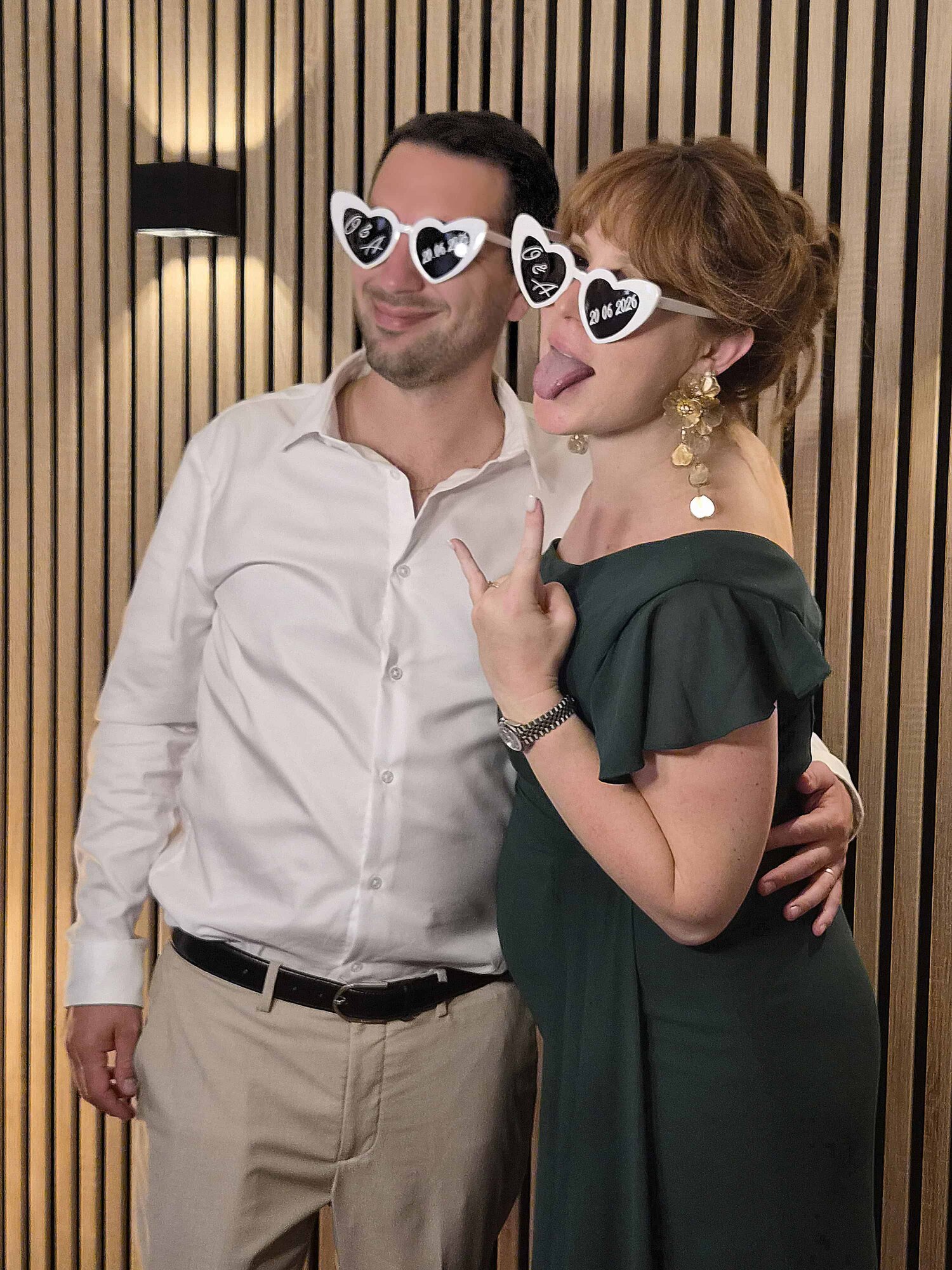 La témoin des mariés pose avec son mari devant le photobooth pendant la réception au Domaine de Crécy
