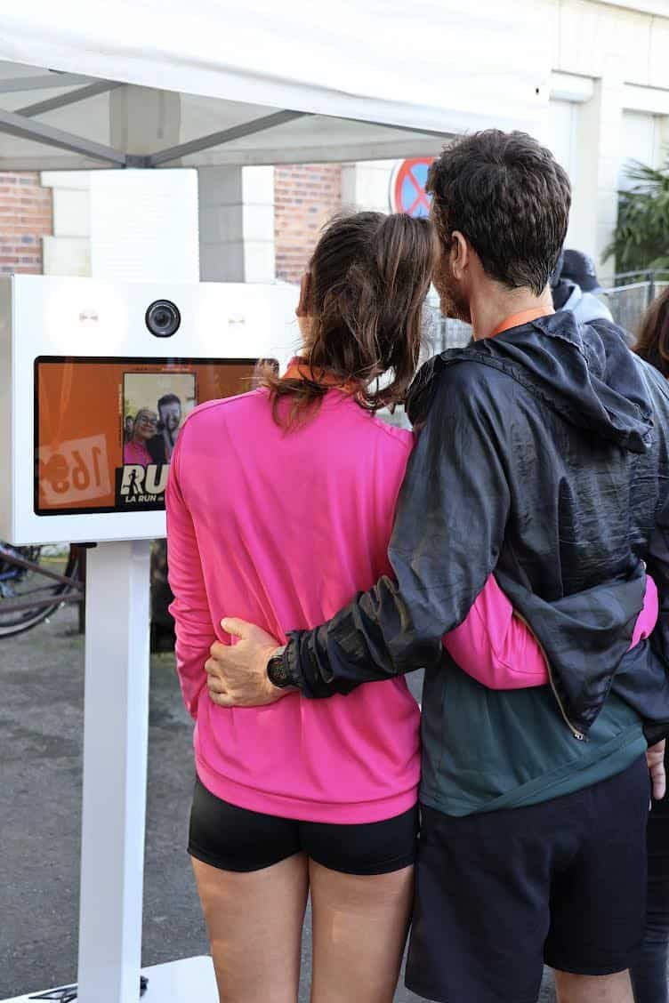 Couple de coureurs devant le photobooth FunkyPix après la Run In Claye - impression photo personnalisée sur place