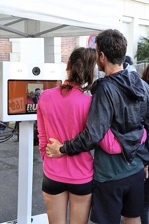 Couple de coureurs devant le photobooth FunkyPix après la Run In Claye - impression photo personnalisée sur place